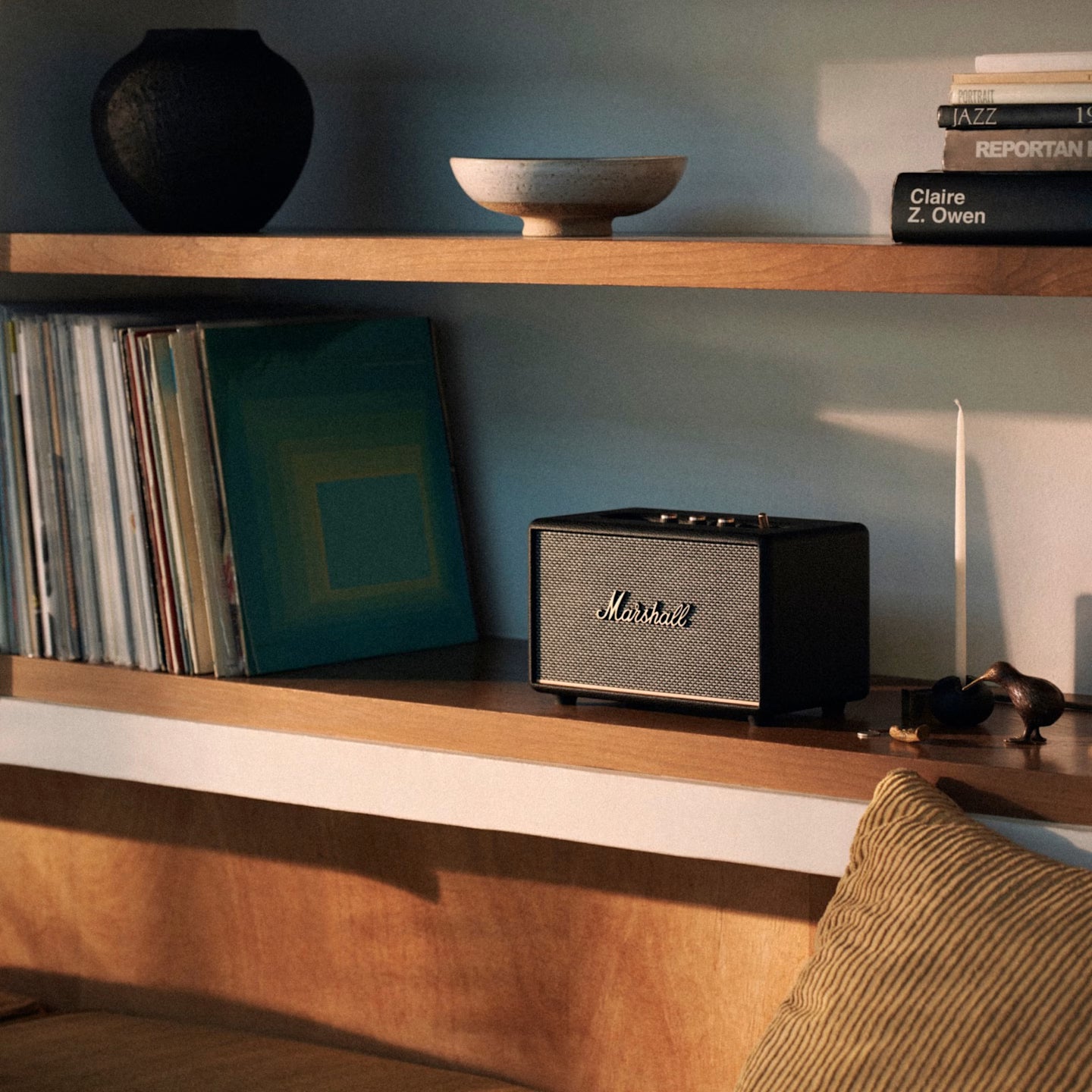 Marshall speaker on a wooden shelf with books