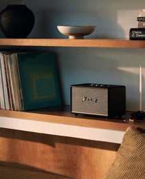 Marshall speaker on a wooden shelf with books